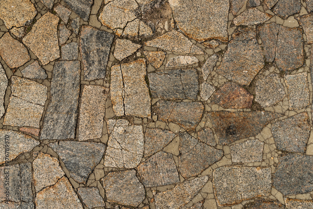 Wall mural the texture of the sidewalk of chaotic granite stones of different colors with many cracks