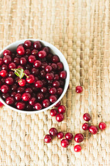 A plate full of fresh cherries on a natural wicker napkin