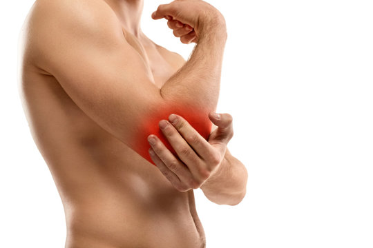 Crop guy rubbing aching elbow
