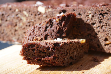 Fresh chocolate cake, brownie with nuts on top of a wood plate at the restaurant. Sweet and moist of chocolate dessert  