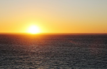 Sunset on the west coast of Australia. Moments of reflection. Calm sea. Bright sun.