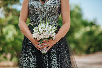 Obraz premium Girl in evening dress holding a bouquet of white roses
