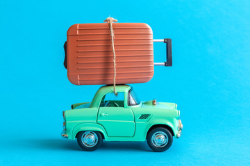 Car toy and luggage abstract isolated on blue.