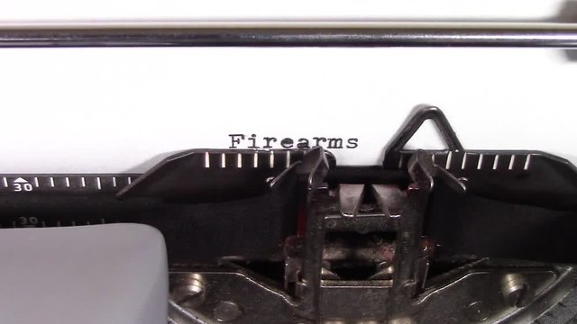 A close up video of the words "Firearms 101 " being typed on white paper in an old manual typewriter. Shot in macro.