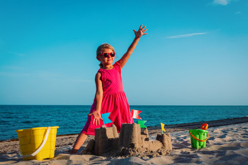 happy little girl play with sand on beach
