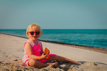 cute little girl play with sand on beach