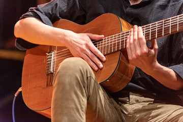 hands of musician playing Brazilian 7-string guitar on a stage