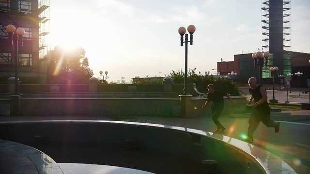 Two acrobatic men running up and jump over the obstacles