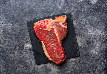 Raw T-bone steak on slate board