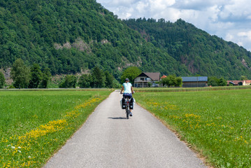 individual woman on a bike trip between mountains in a valley