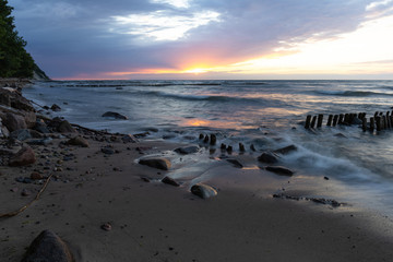 Fototapeta na wymiar baltic sea with old breakwaters at long shutter speed at sunset
