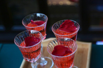 Red Cocktail in fancy glasses on wood plate and table in at restaurant