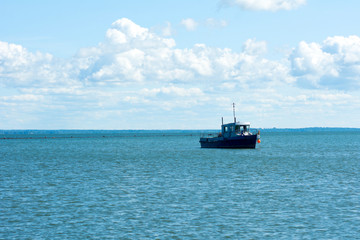 Old wooden fishing boat trawler on sea.