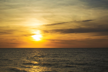 Beautiful fiery sunset sky on the beach. Sunrise over the sea and beautiful cloudscape.