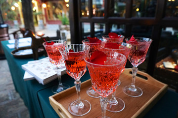 Red Cocktail in fancy glasses on wood plate and table in at restaurant