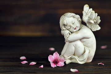 Sympathy card with sleeping angel and spring flowers, copy space