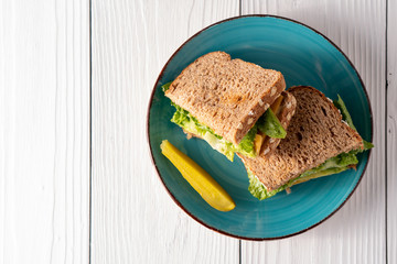 Avocado cheese and lettuce sandwich with pickle side