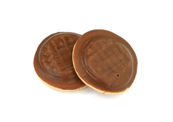 Chocolate coated biscuit cakes with the orange filling isolated over the white background.