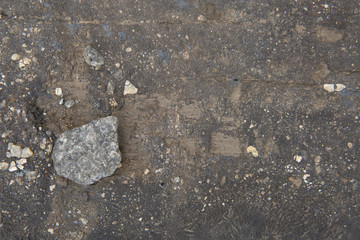 Gray stone lies on the board in the ground