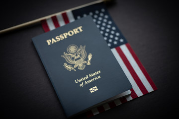 American Flag covered with Passport of USA on Dark surface.