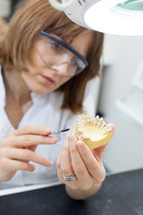 dental technician shaping a prosthesis tooth