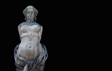 The goddess of love in Greek mythology, Aphrodite (Venus in Roman mythology) Fragment of ancient statue against black background.