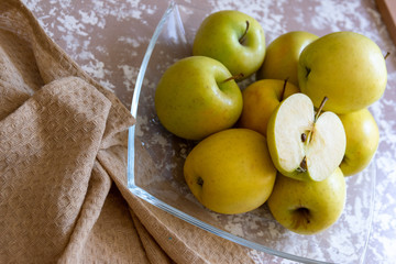 apples on a plate on the table in the kitchen. Chantecler apples.