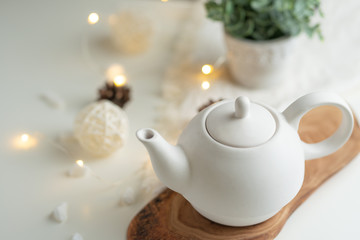 Ceramic white teapot with accessories on a white table, horizontal frame, tea time, tea drinking, retual tea making
