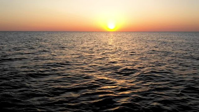 Sea sunrise early morning. Aerial View. Black Sea Sunset. Orange sky and low tide. Sea waves in the rays of a sunset. Sunset on the beach in summer season. Seascape. Sun over the skyline and sea waves