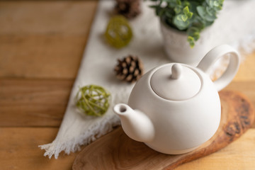 Ceramic white teapot with accessories on a wooden table, horizontal frame, tea time, tea drinking, retual tea making