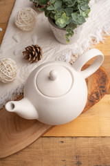 Ceramic white teapot with accessories on a wooden table, vertical frame, tea time, tea drinking, retual tea making