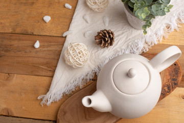 Ceramic white teapot with accessories on a wooden table, horizontal frame, tea time, tea drinking, retual tea making