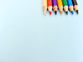 Color pencils isolated on light blue background with copy space.