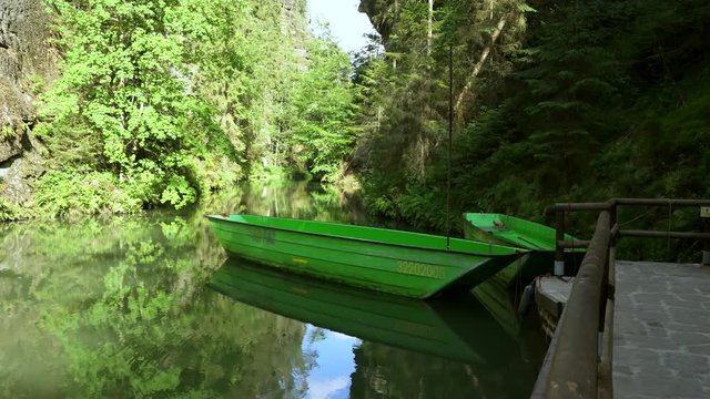 View from the green boats to the rocky canyon of the Kamenice River. Bohemian Switzerland, The sun created beautiful beams going through the trees.