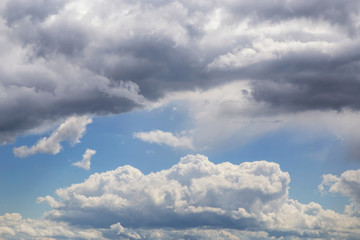 Cumulus fluffy white clouds in sunlight against blue sky background, heaven	