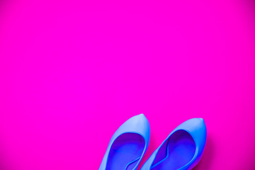 Blue high heeled shoes pink purple background - top view - heels pointing right