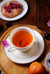cup of fresh tea with berry bakery