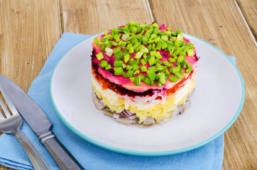 Layered salad with vegetables and herring.