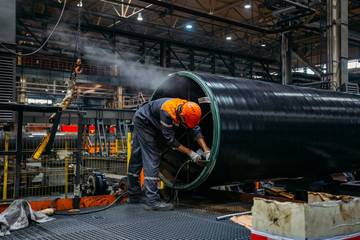 Worker installs clamping ring on coated pipe