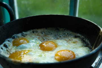 four fried eggs in butter in a pan in the village
