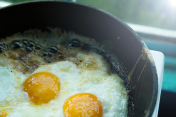 four fried eggs in butter in a pan in the village