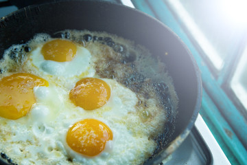 four fried eggs in butter in a pan in the village