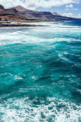 Fototapeta na wymiar Beautiful view of the coastline of Gran Canaria, rocky shore, atlantic waves, turquise water. 