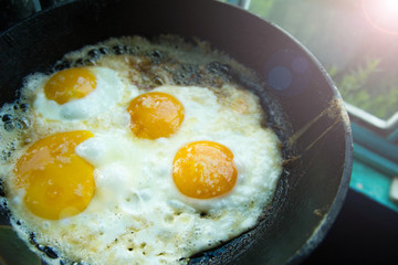 four fried eggs in butter in a pan in the village