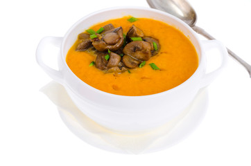 Yellow vegetable cream soup with fried champignons in white bowl, isolated.