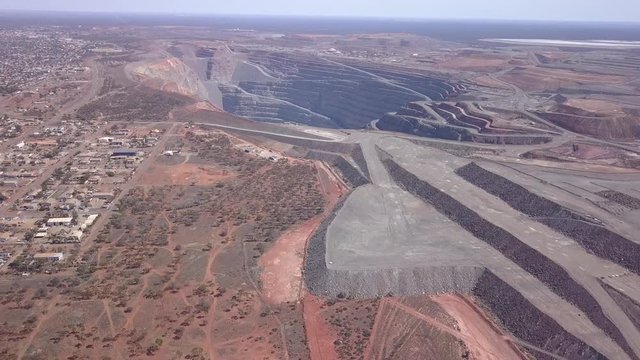 The gigantic mine Kalgoorlie extends to the horizon. Aerial view of the canyon-like mine with its huge trucks in the south west of australia