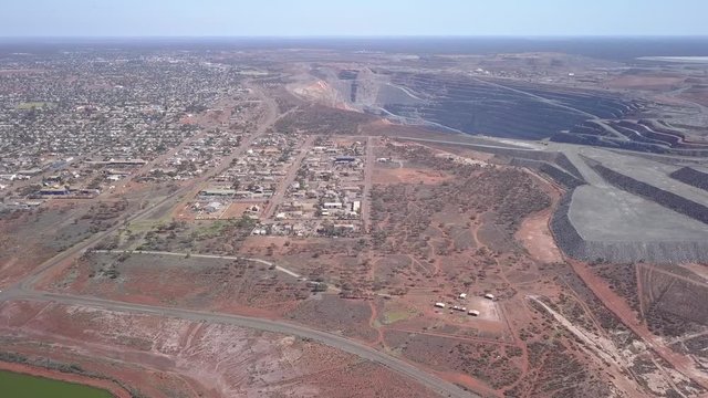 The gigantic mine Kalgoorlie extends to the horizon. Aerial view of the canyon-like mine with its huge trucks in the south west of australia