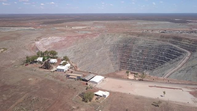 The gigantic mine Kalgoorlie extends to the horizon. Aerial view of the canyon-like mine with its huge trucks in the south west of australia