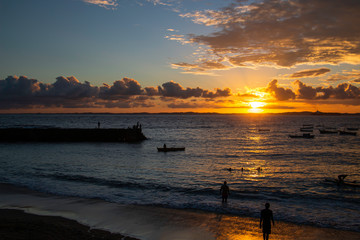 Sunset on the beach, with silhouettes of people at the seaside