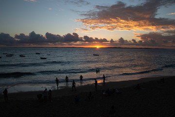 Sunset on the beach, with silhouettes of people at the seaside